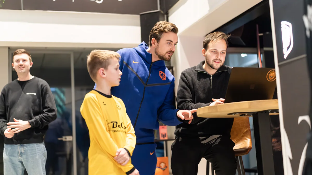KNVB-coach en WePlay-medewerker checken het toernooischema met een jonge deelnemer