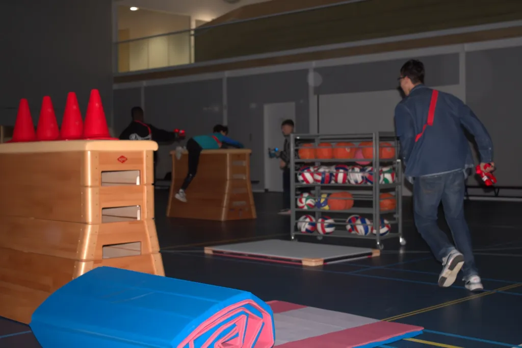 Groep kinderen speelt lasergamen op school met opblaasbare hindernissen