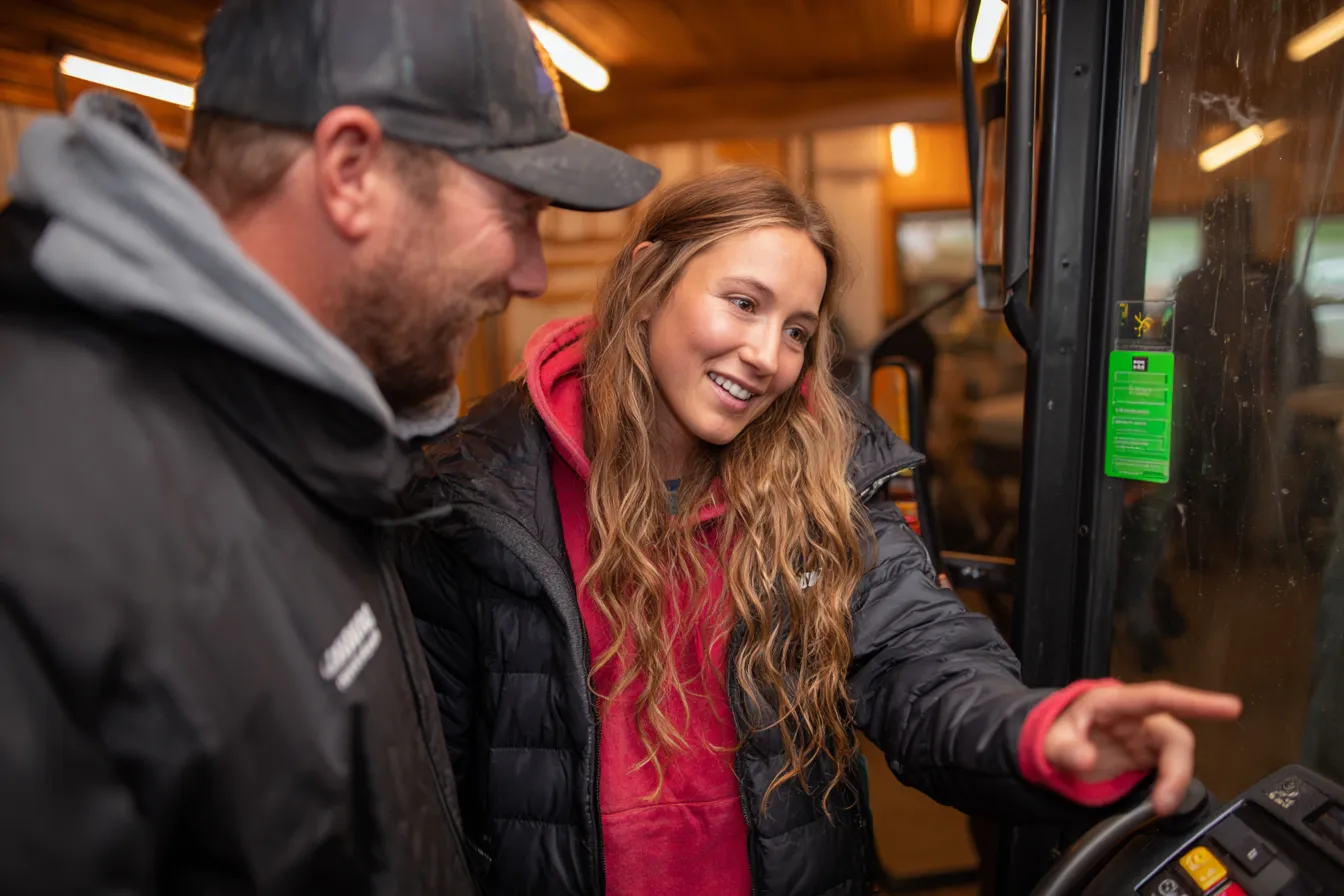 Vriendelijke eventmanager legt Farming Simulator uit aan deelnemer voor aanvang van het event