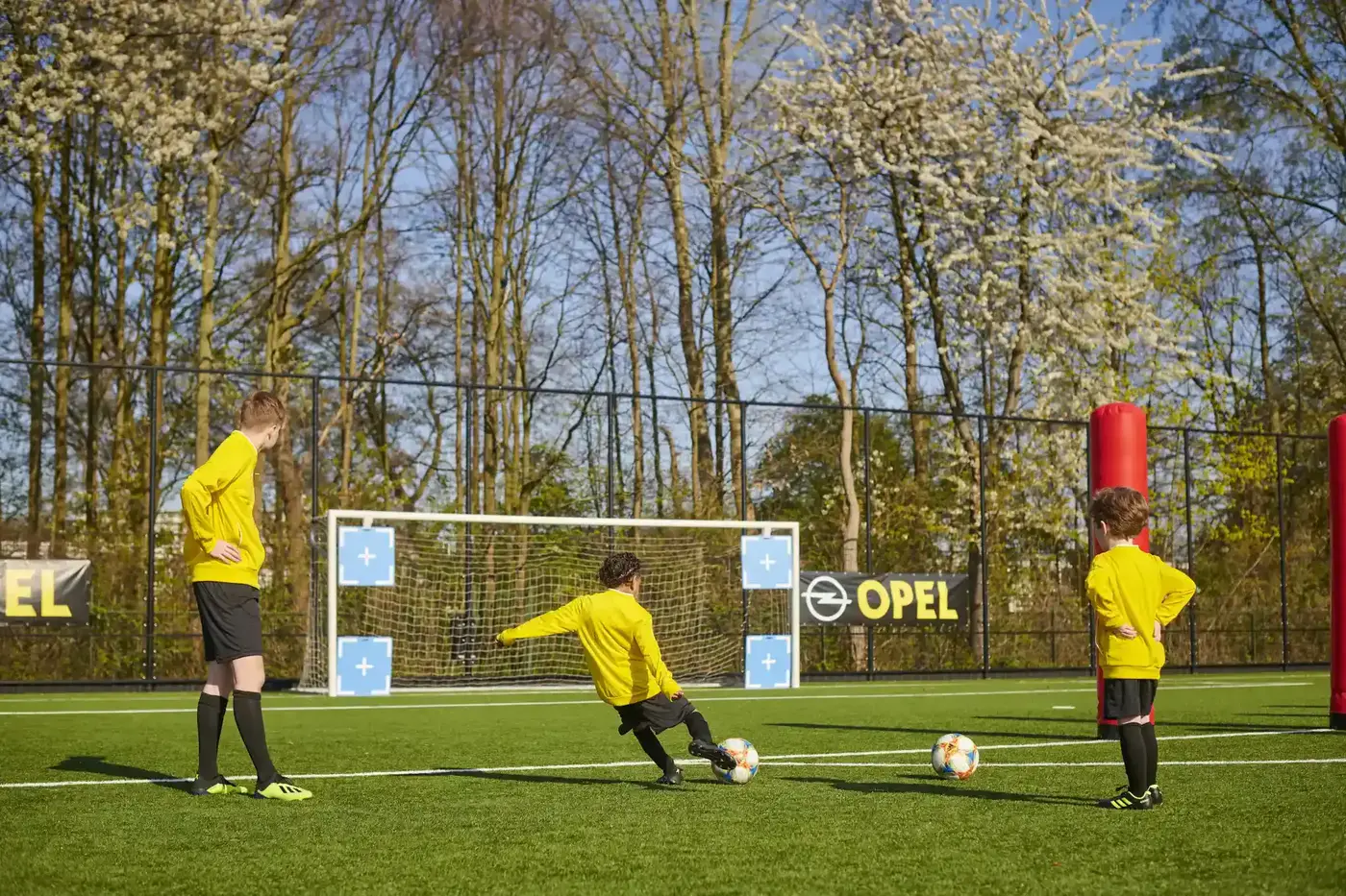 Jongeren doen mee aan voetbaluitdagingen tijdens FIFA Skill Games op een kunstgrasveld