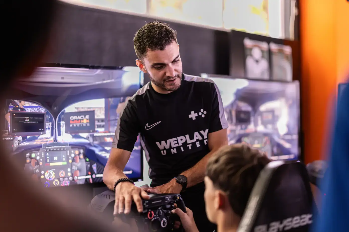 Deelnemer racet in een professionele F1 simulator met Playseat-stoel en groot scherm