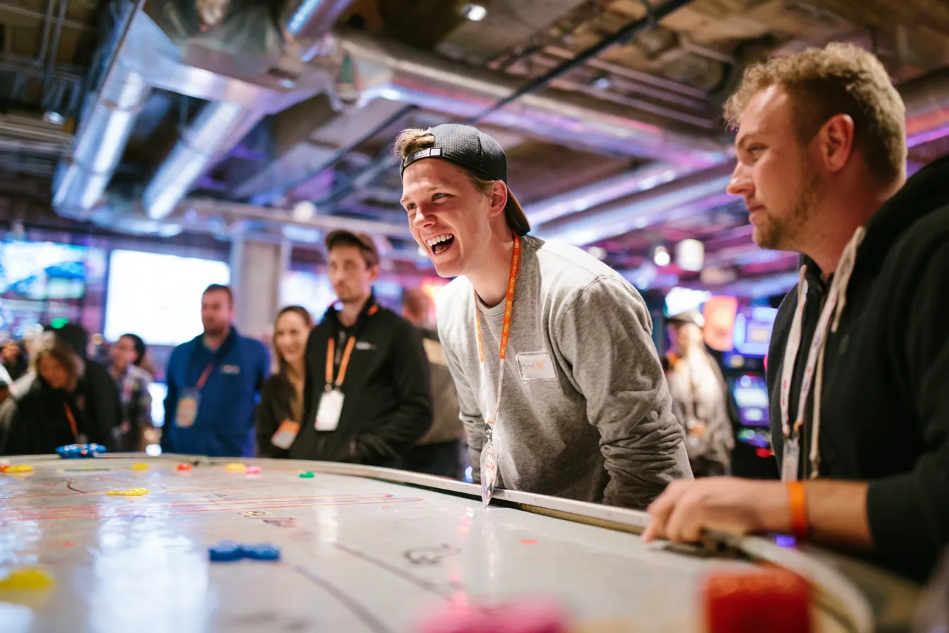 Eventmanager begeleidt enthousiast deelnemers bij de retro arcade spellen op een WePlay United event