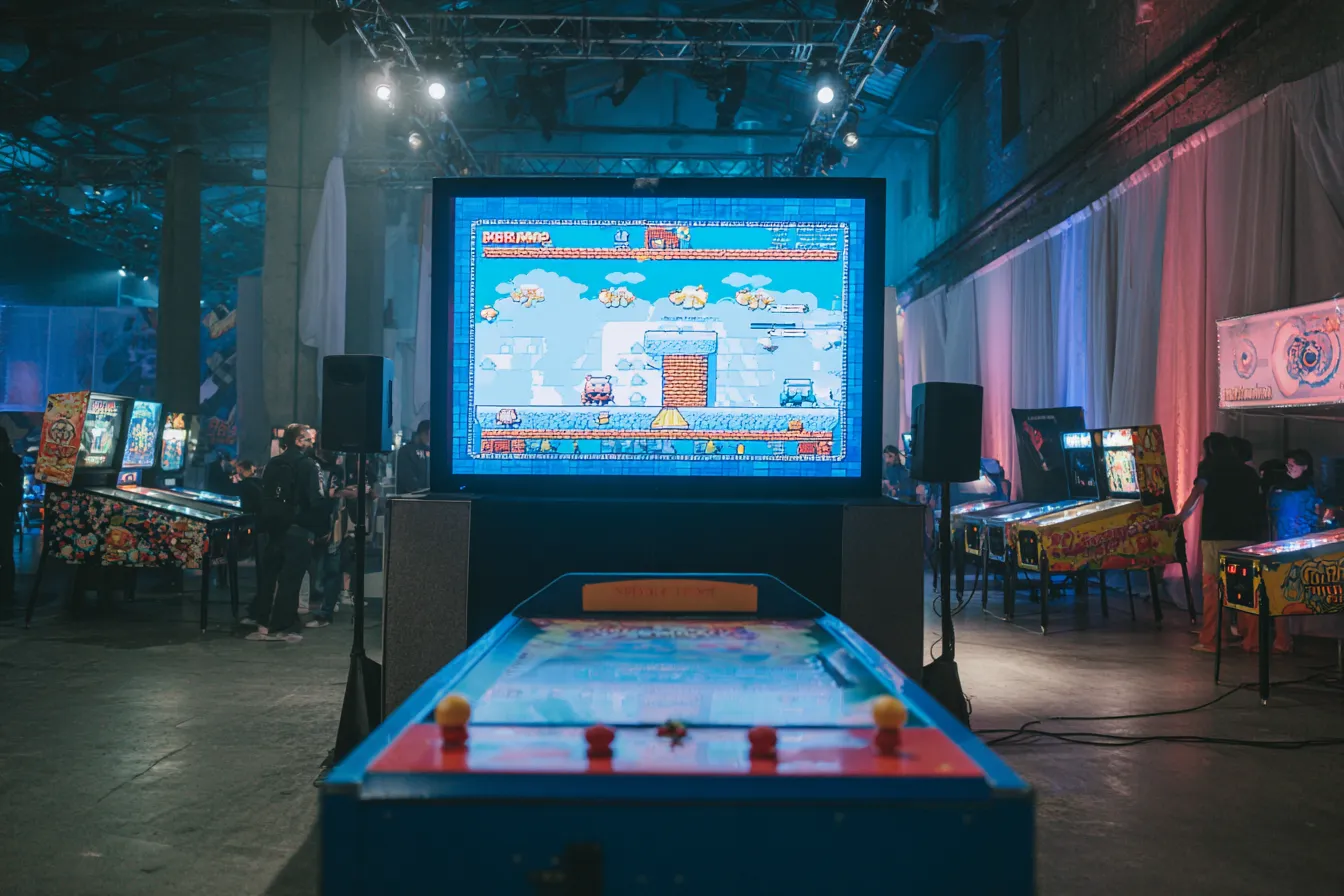 Klassieke retro gaming-opstelling met vintage consoles, controllers en beeldschermen op een evenement