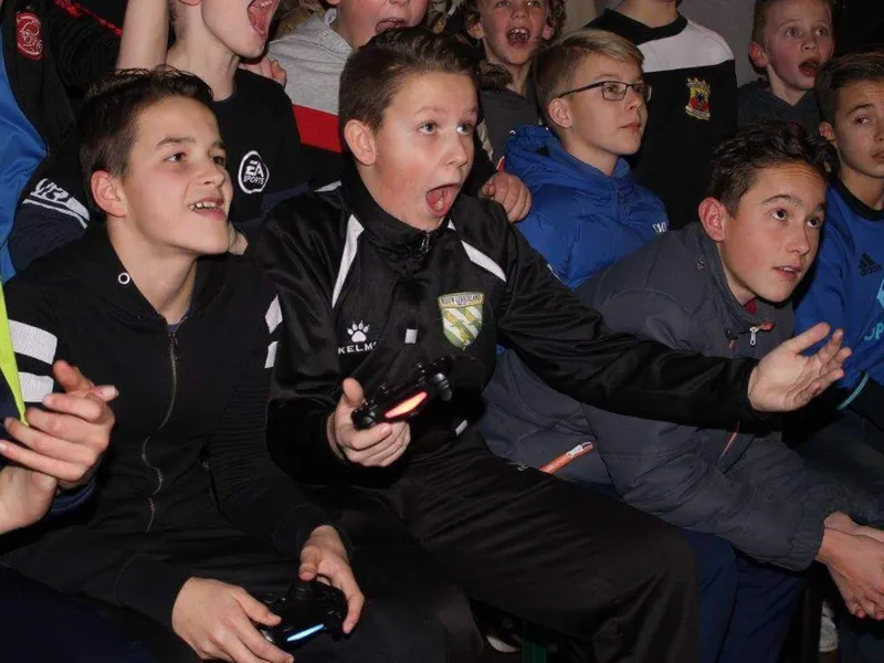 Enthousiaste jeugdspelers met controllers tijdens een FIFA-toernooi bij VV Nieuw-Lekkerland